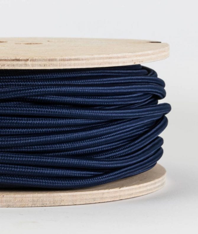 closeup of navy fabric cable on reel against white background