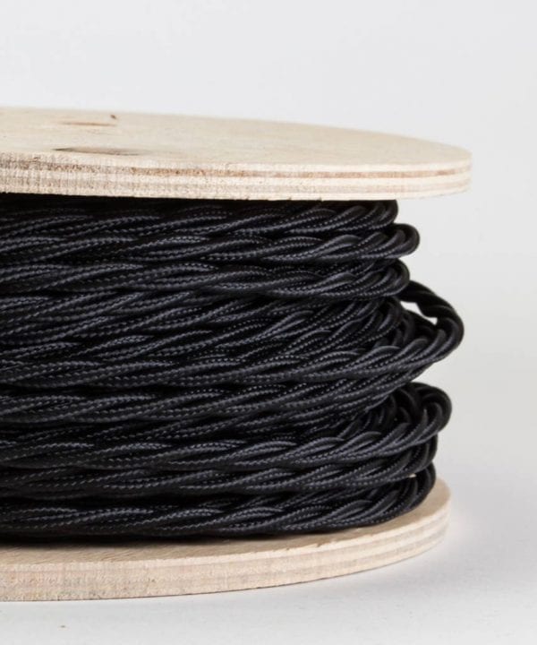 closeup of navy twisted fabric cable on reel against white background