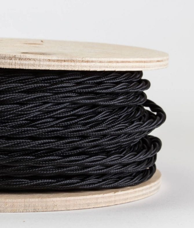 closeup of navy twisted fabric cable on reel against white background