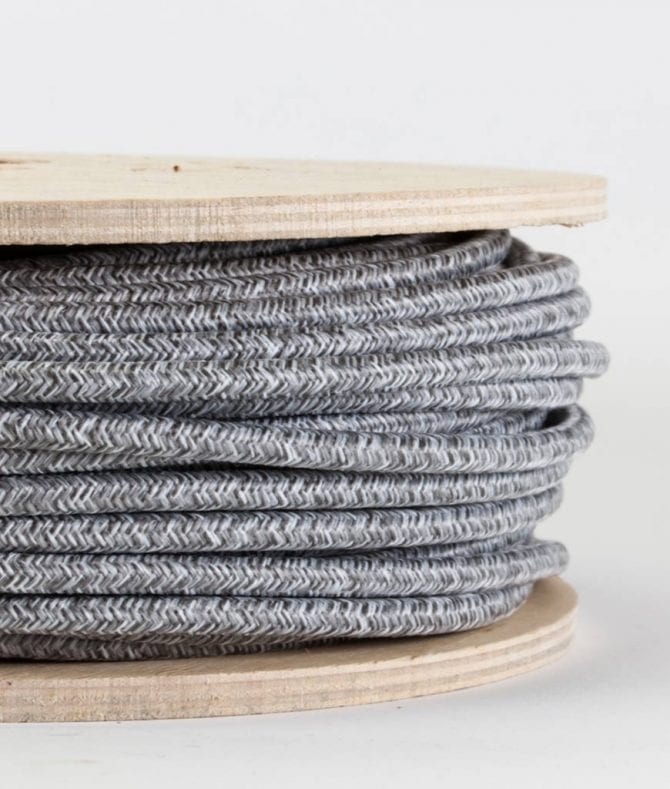 closeup of grey jumper cable on reel against white background