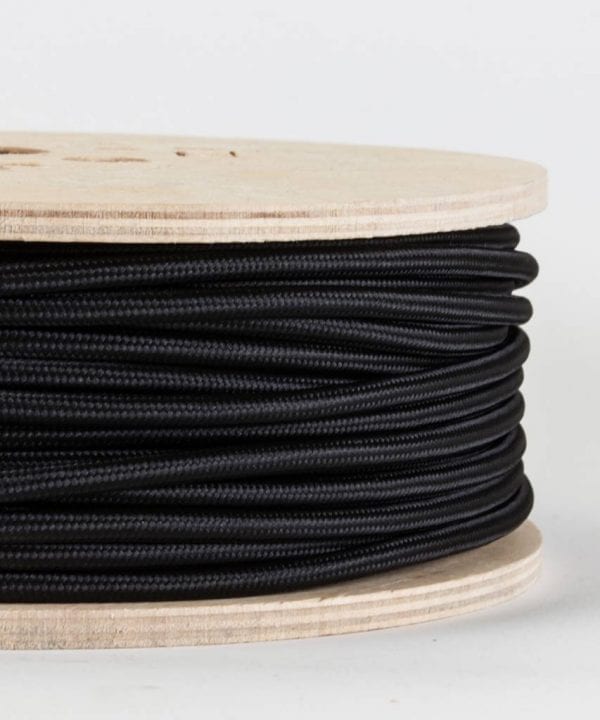 closeup of black fabric cable on reel against white background
