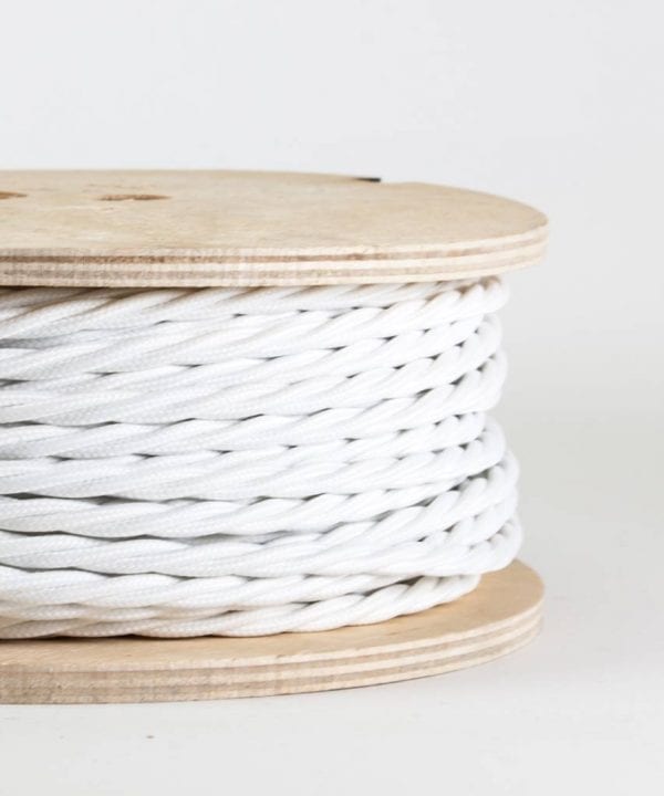 closeup of white twisted fabric cable on reel against white background