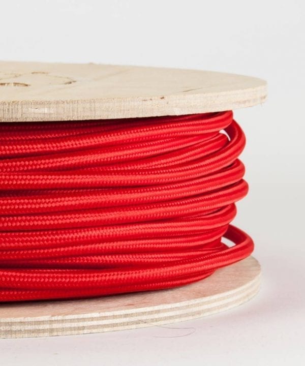 closeup of red fabric cable on reel against white background