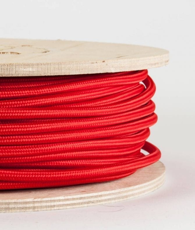 closeup of red fabric cable on reel against white background