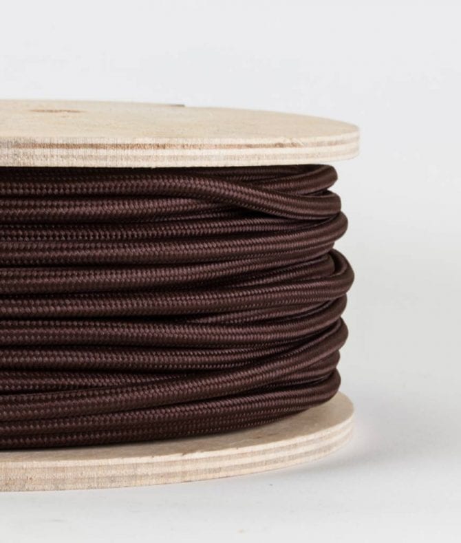 closeup of brown fabric cable on reel against white background