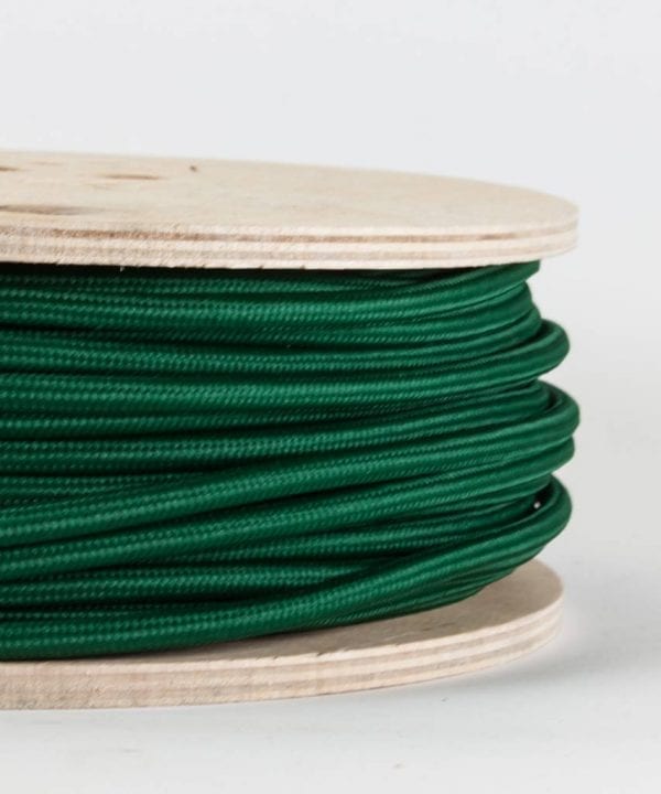 closeup of bottle green fabric cable on reel against white background