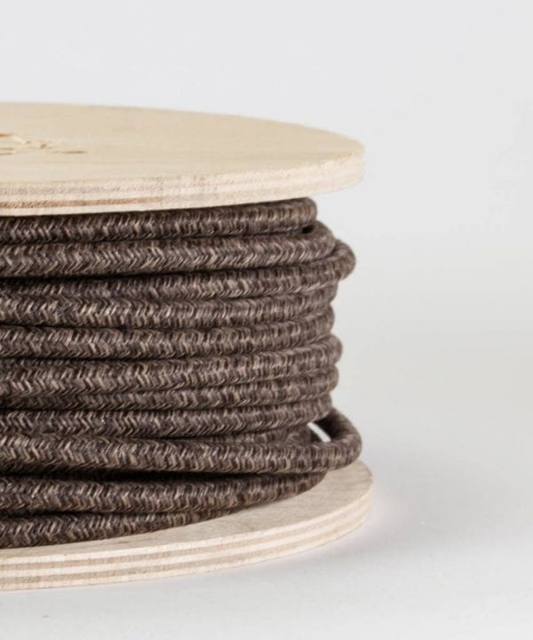 closeup of brown jumper fabric cable on reel against white background