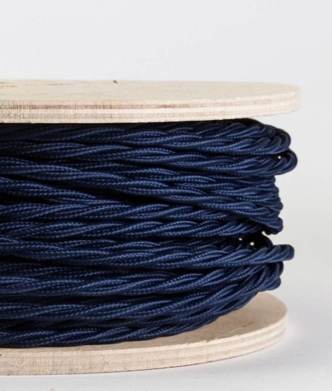 closeup of navy twsited fabric cable on reel against white background