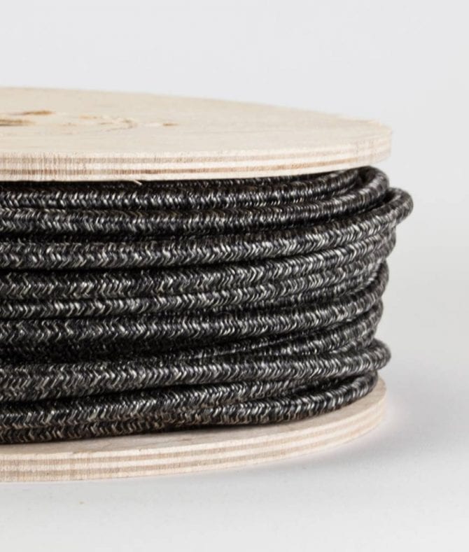 closeup of fisherman's jumper fabric cable on reel against white background