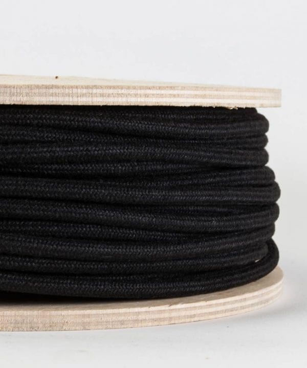 closeup of matt black fabric cable on reel against white background