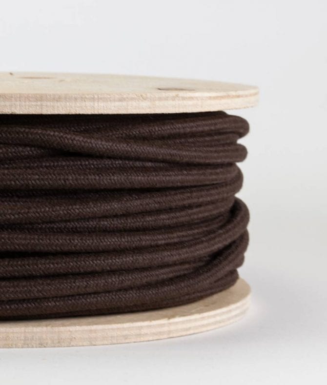 closeup of matt brown fabric cable on reel against white background