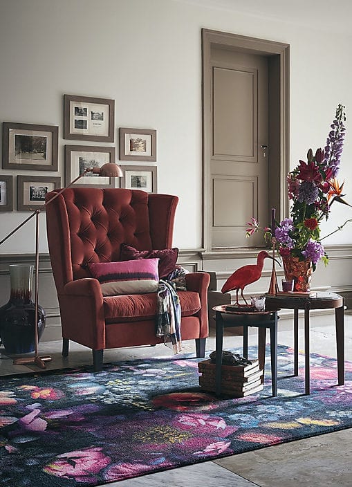 white living room soft brown painted woodwork, red velvet armchair and floral rug