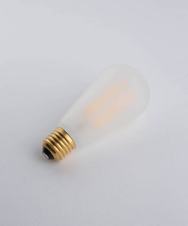 frosted pear squirrel cage filament bulb with a warm glow against a white background