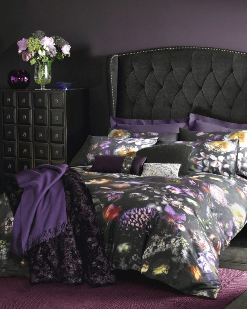 purple bedroom with black velvet bed and dark floral bedspread