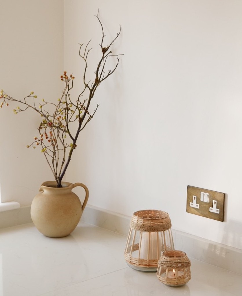 smoked gold and white double socket installed on an off-white wall