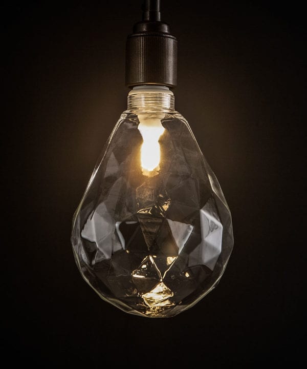 lit pear geometric e27 led bulb clear pear shaped bulb against black wall