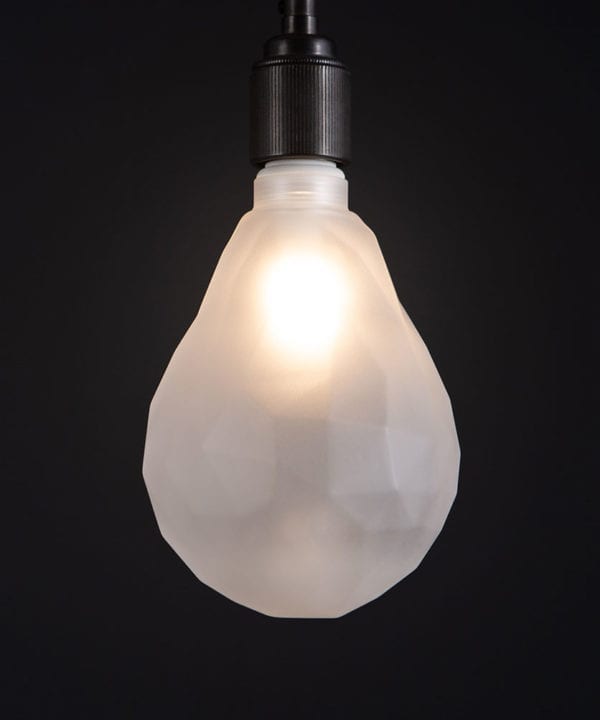 lit pear geometric e27 led bulb frosted pear shaped bulb against black wall