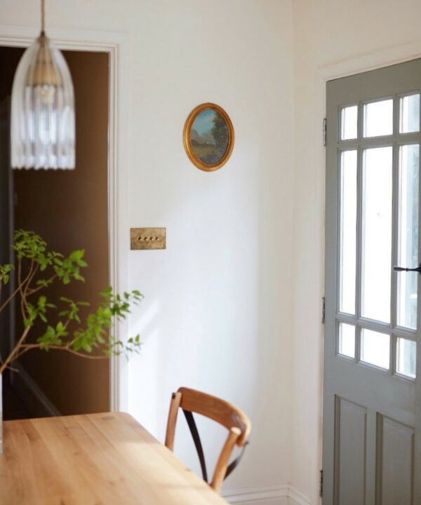 smoked gold and gold quadruple dimmer switch installed on a white wall in a kitchen diner