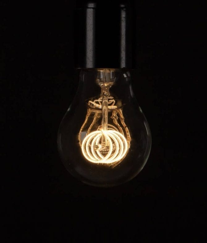 LED filament bulbs quad loop warm glow bulb against a black background