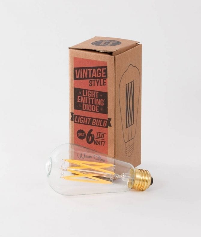 squirrel cage filament light bulb with box against white background