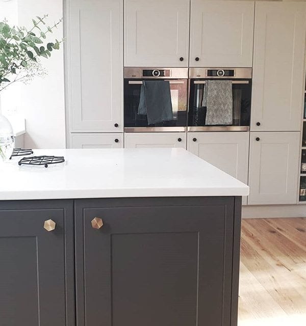 Bauhaus Hexagonal Knob on dark grey cupboard in a grey and white kitchen