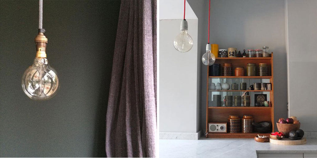 bare bulb sin b22 bulb holder suspended from black and white fabric cable in a white kitchen