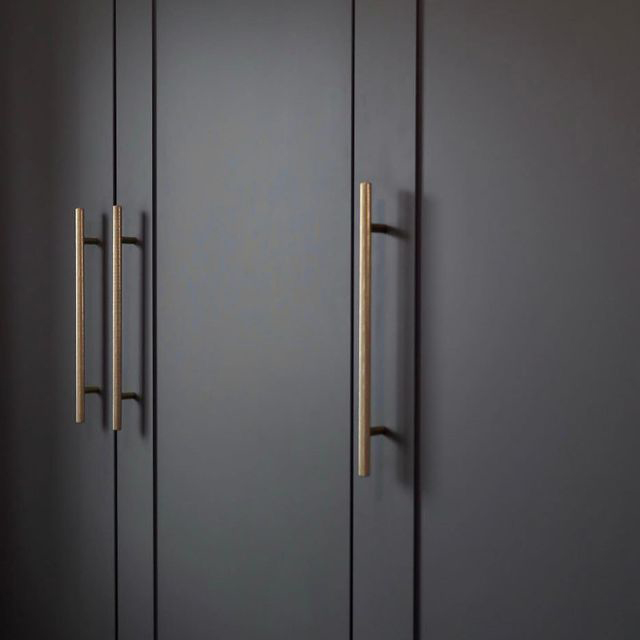 gold skyscraper knurled handle on dark grey cupboards