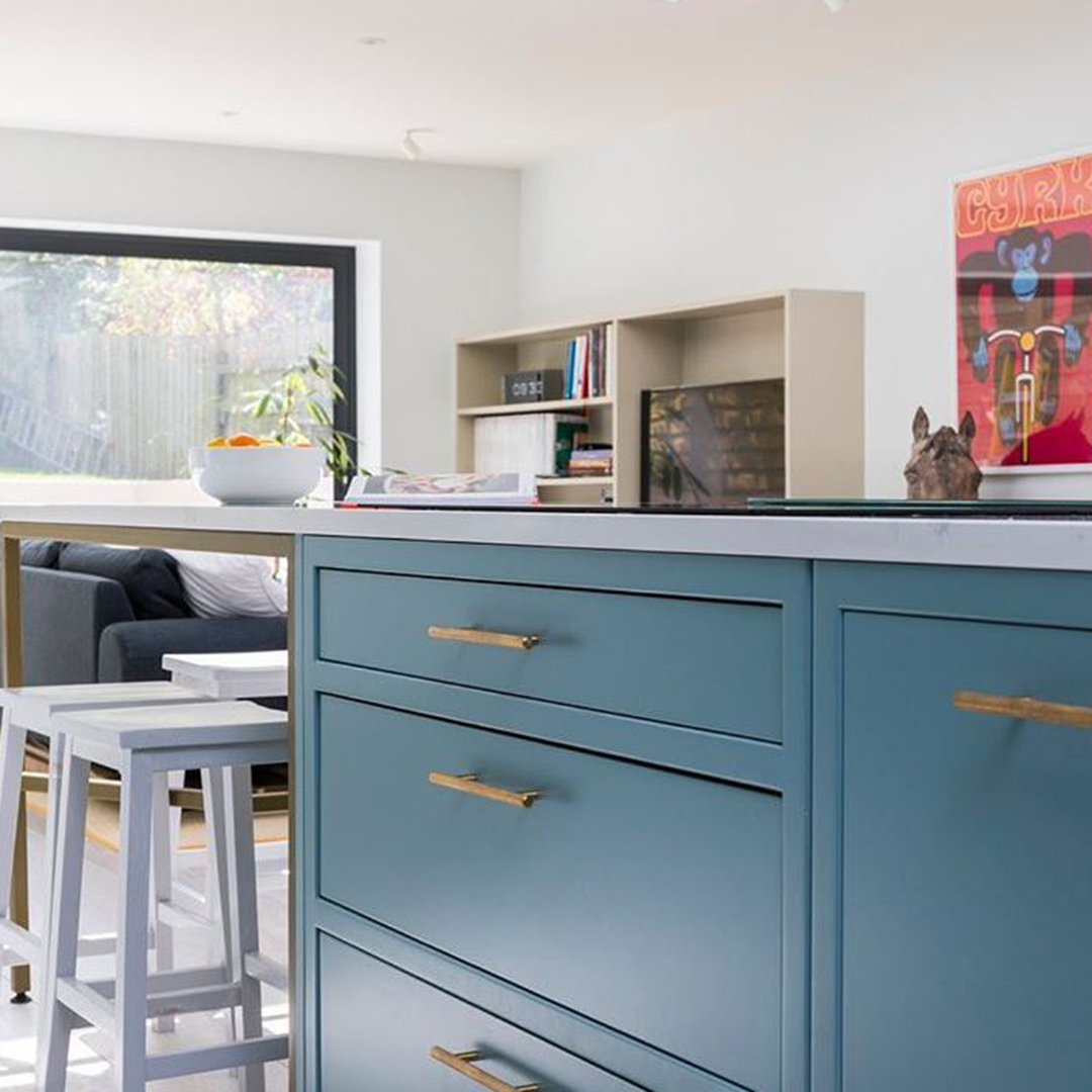 gold skyscraper door handles on blue cupboards in blue and white kitchen