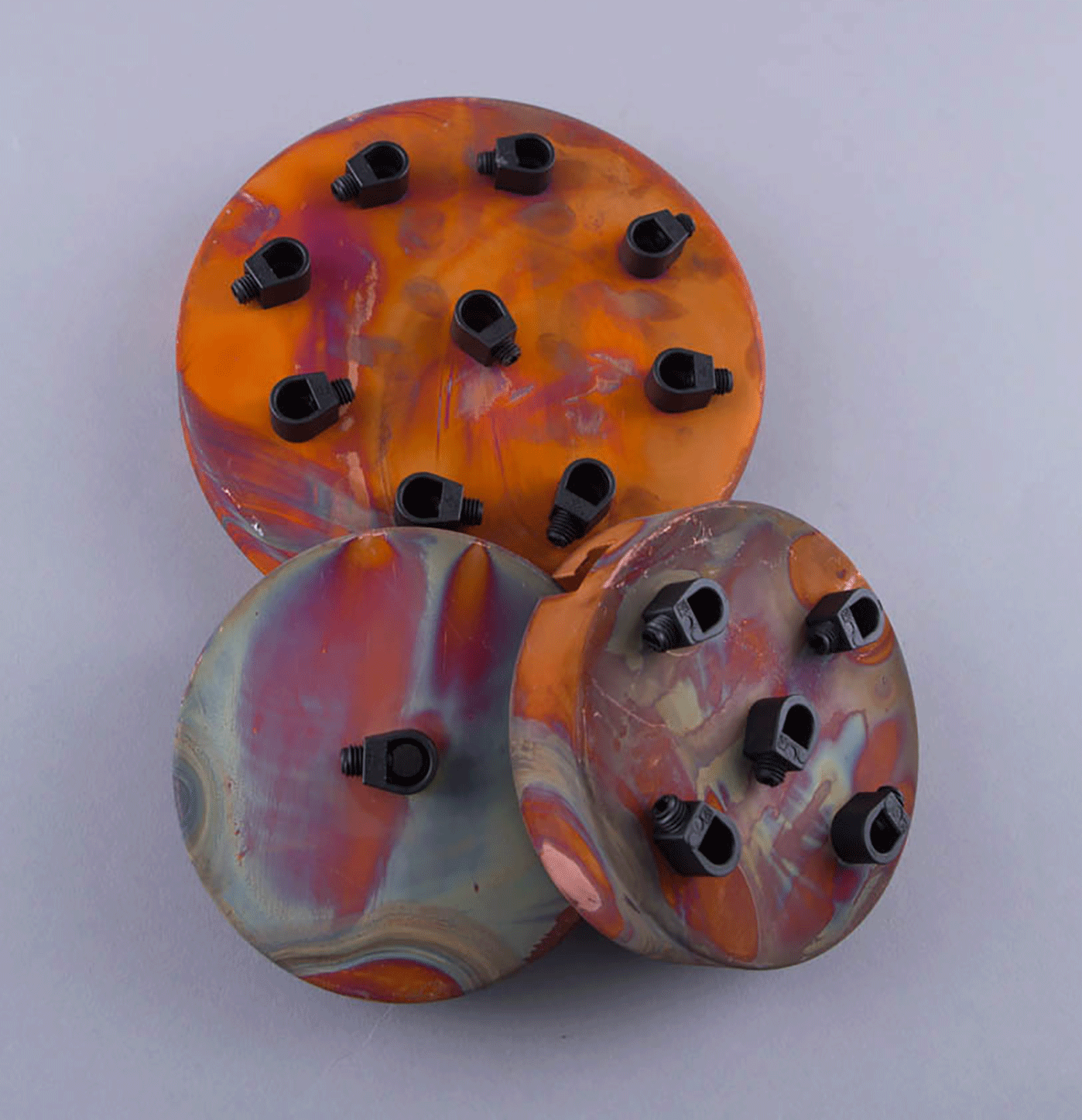 group shot of single point, five-point andeight-point tarnished copper ceiling roses against soft grey background