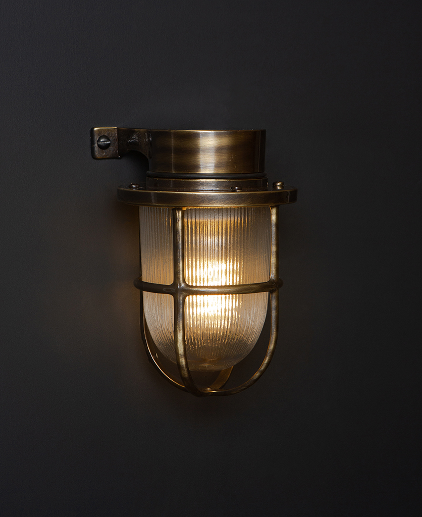 lit simon aged brass exterior bulkhead lights against black background