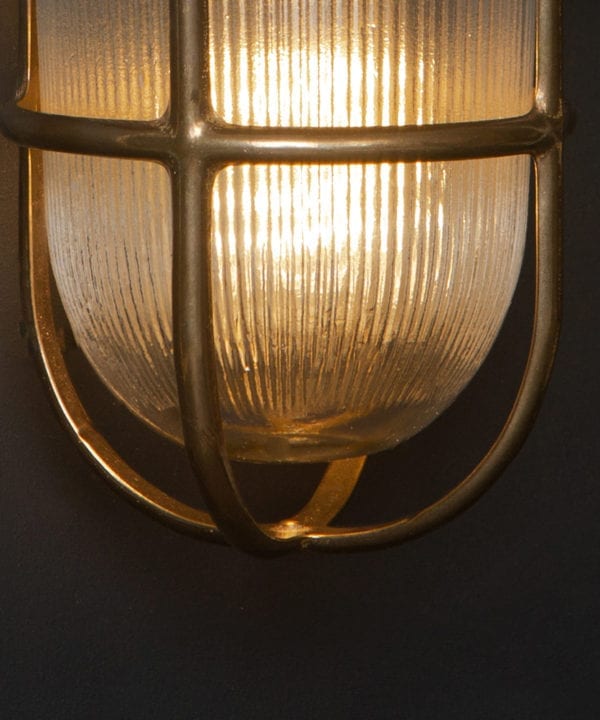close up of lit brass simon exterior bulkhead lights against black background