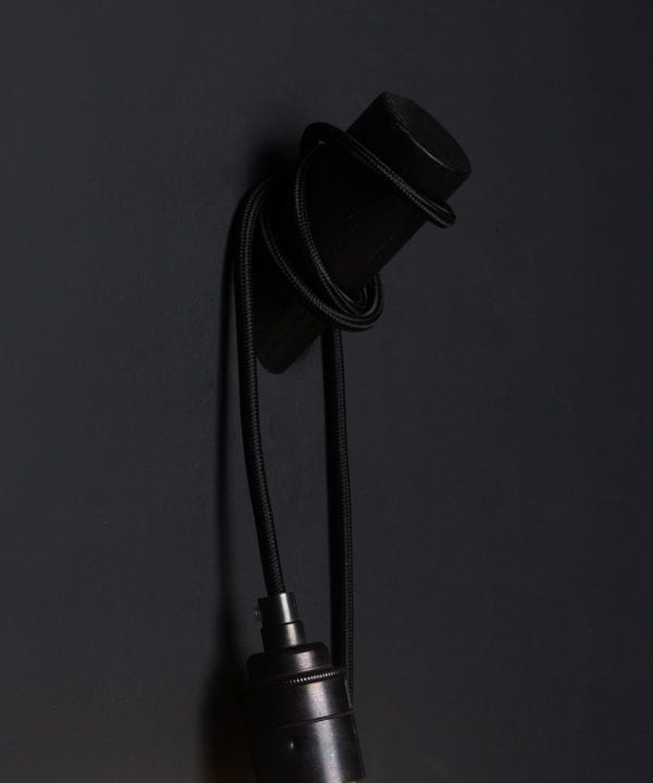 peg wall light black with black cable closeup against black background