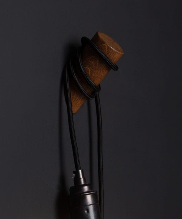 peg wall light oak and black against black background