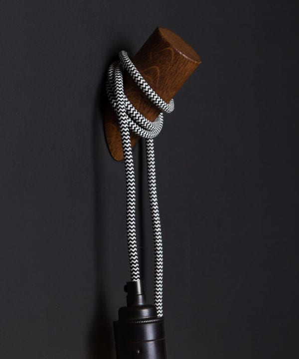 peg wall light oak and mint humbug against black background