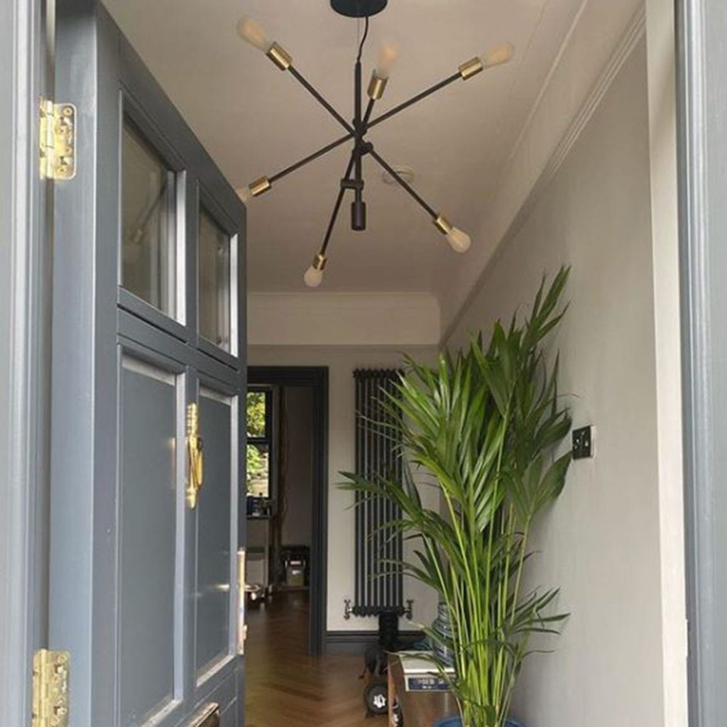 black trikonasana suspended in a light grey hallway