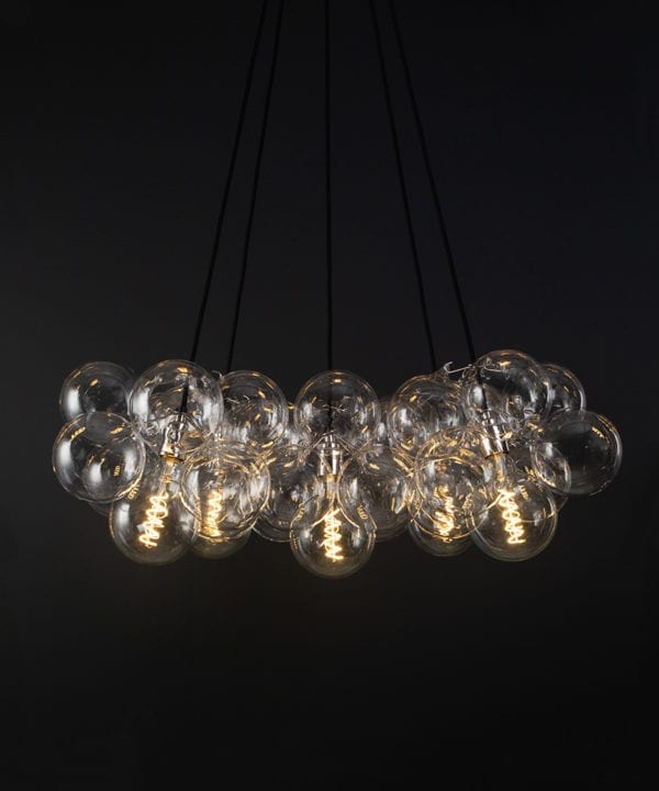 bubble glass chandelier with 40 glass baubles & 5 silver bulb holders suspended from black fabric cable against a black wall
