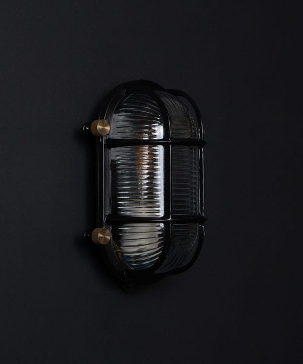 steve unlit black bulkhead light with posh knobs against black background