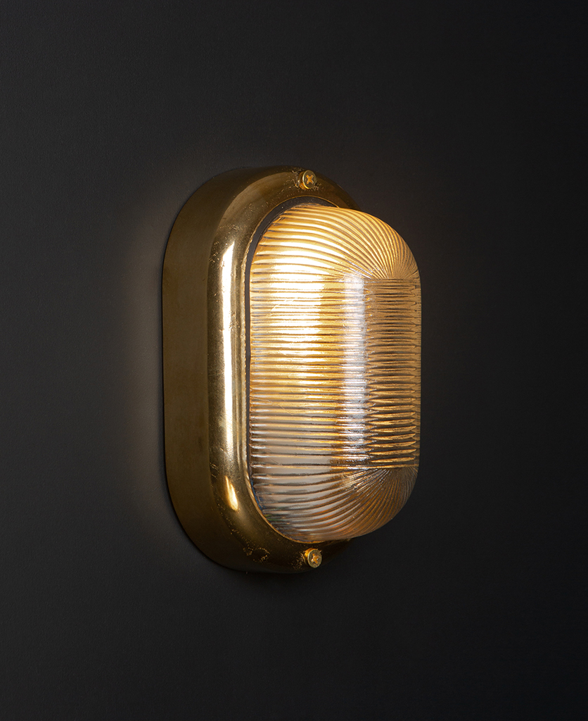 lit brass mike led external light on black wall