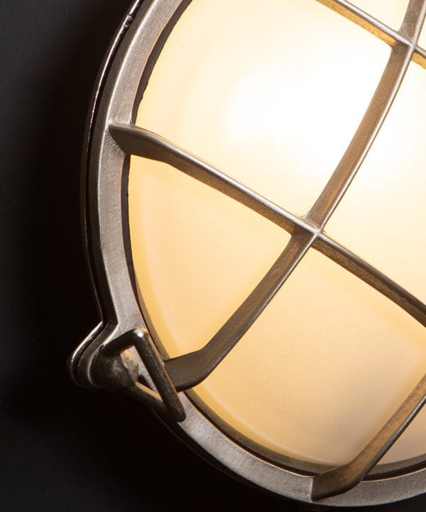 chris silver bulkhead LED Light close up against black wall