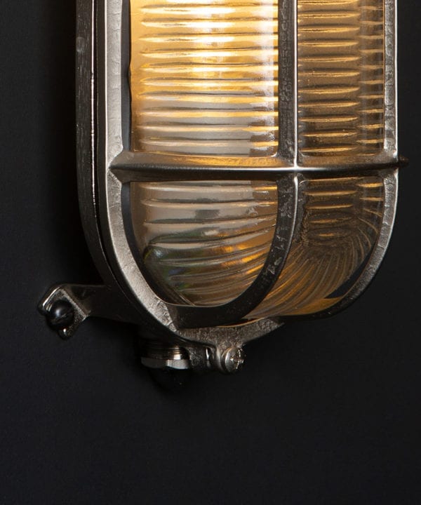 closeup of silver dave bulkhead light against black background