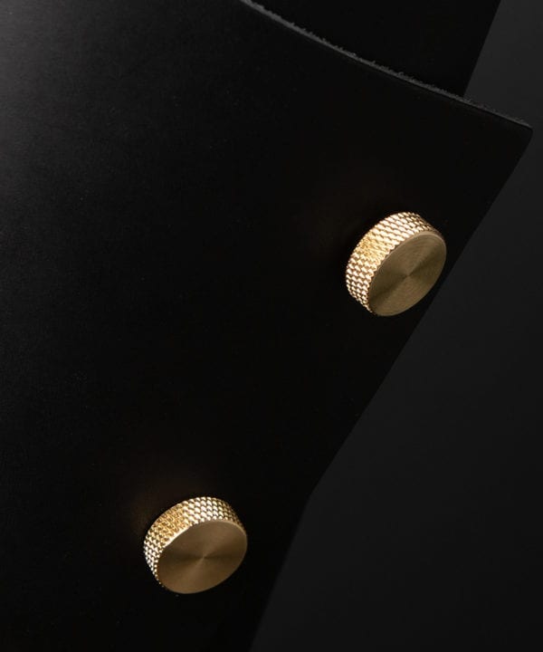 Black and Brass Leather Cuff Lamp Close Up against black background