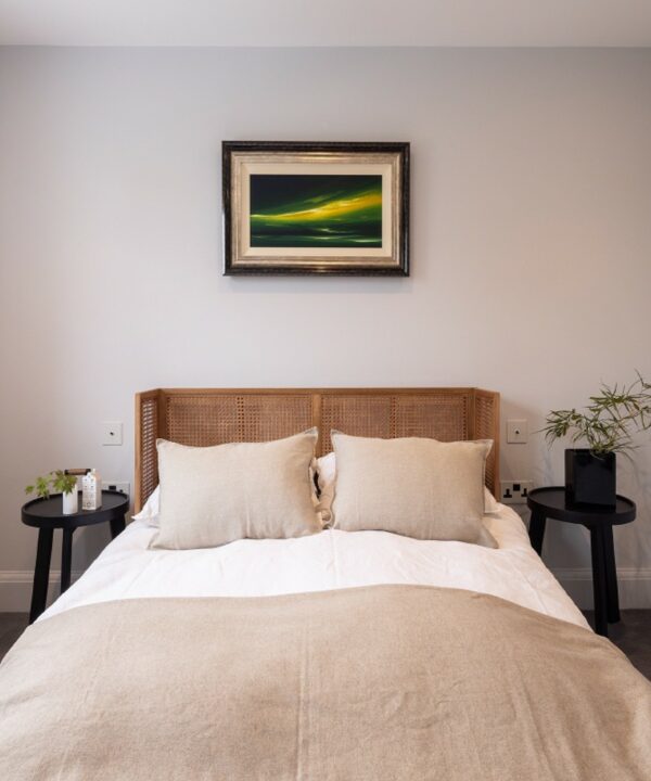 two single white and black dimmer switches positioned on either side of a rattan bed.