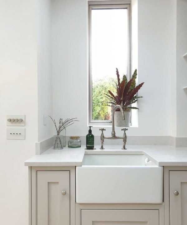 white and silver quad dimmer switch on a white wall in a white and off-white kitchen