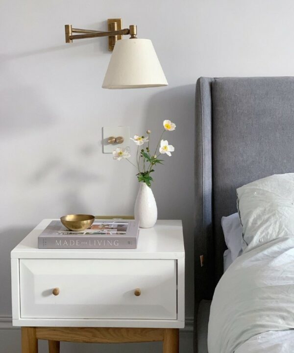 white and gold double dimmer switch installed beside a bed in a soft grey bedroom