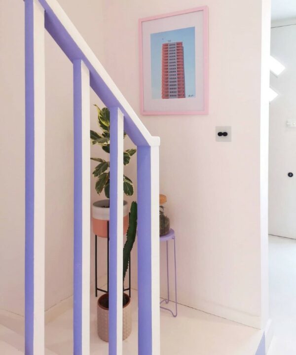 white and black double dimmer switch at the bottom of the stairs in a soft pink, lilac and white hallway