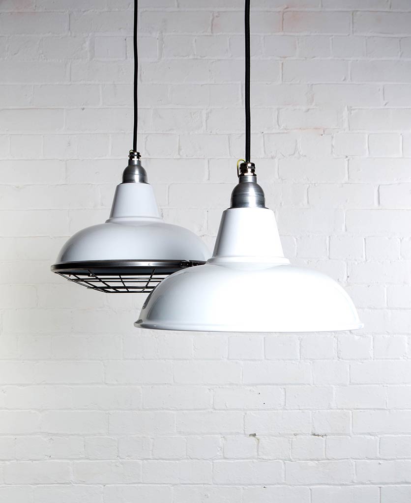 morley white industrial lighting suspended from black fabric cable against white brick wall