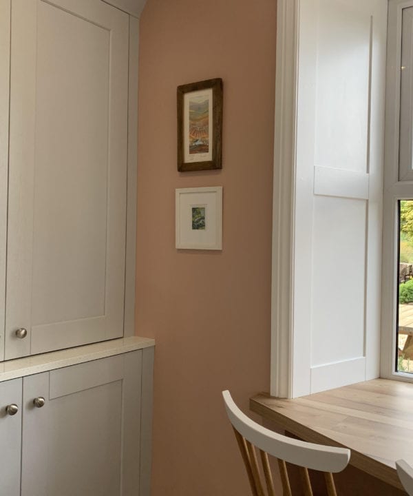 realist silver kitchen drawer knobs on soft grey cupboard doors in a room painted with get plastered paint