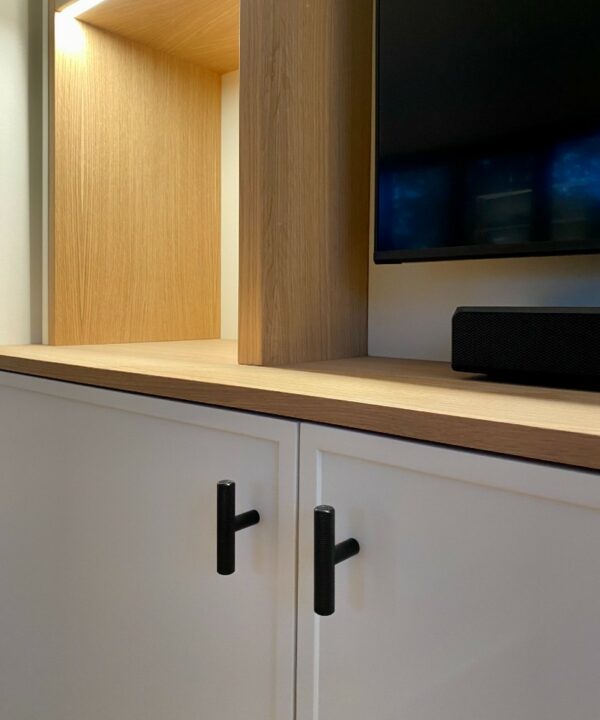 black skyscraper tbar handle installed on a white cupboard beneath a TV