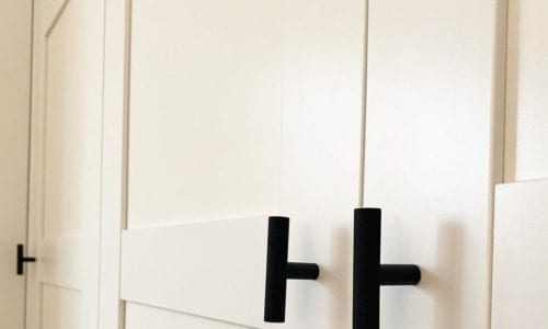 t-bar skyscraper handles in black on white panelled cupboards