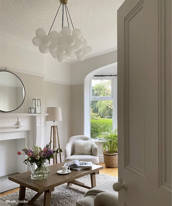 A large frosted bubble chandelier in a neutral living room.